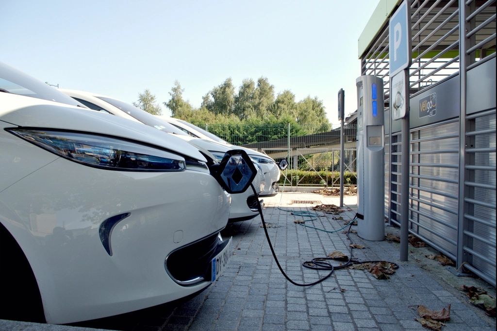 Electric cars plugged into charging stations