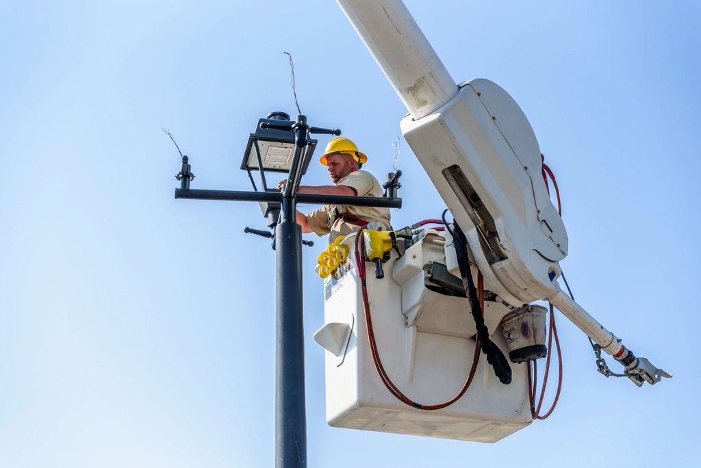 Electrician in a bucket truck working on a light pole