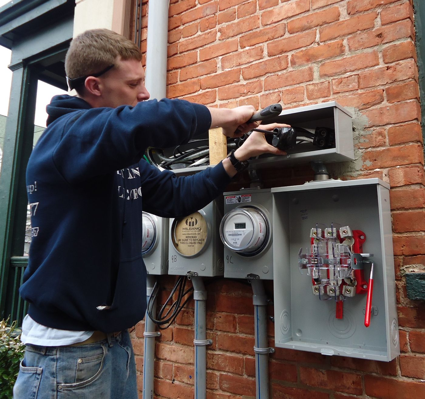 Electrician working on an outdoor service entrance and meter